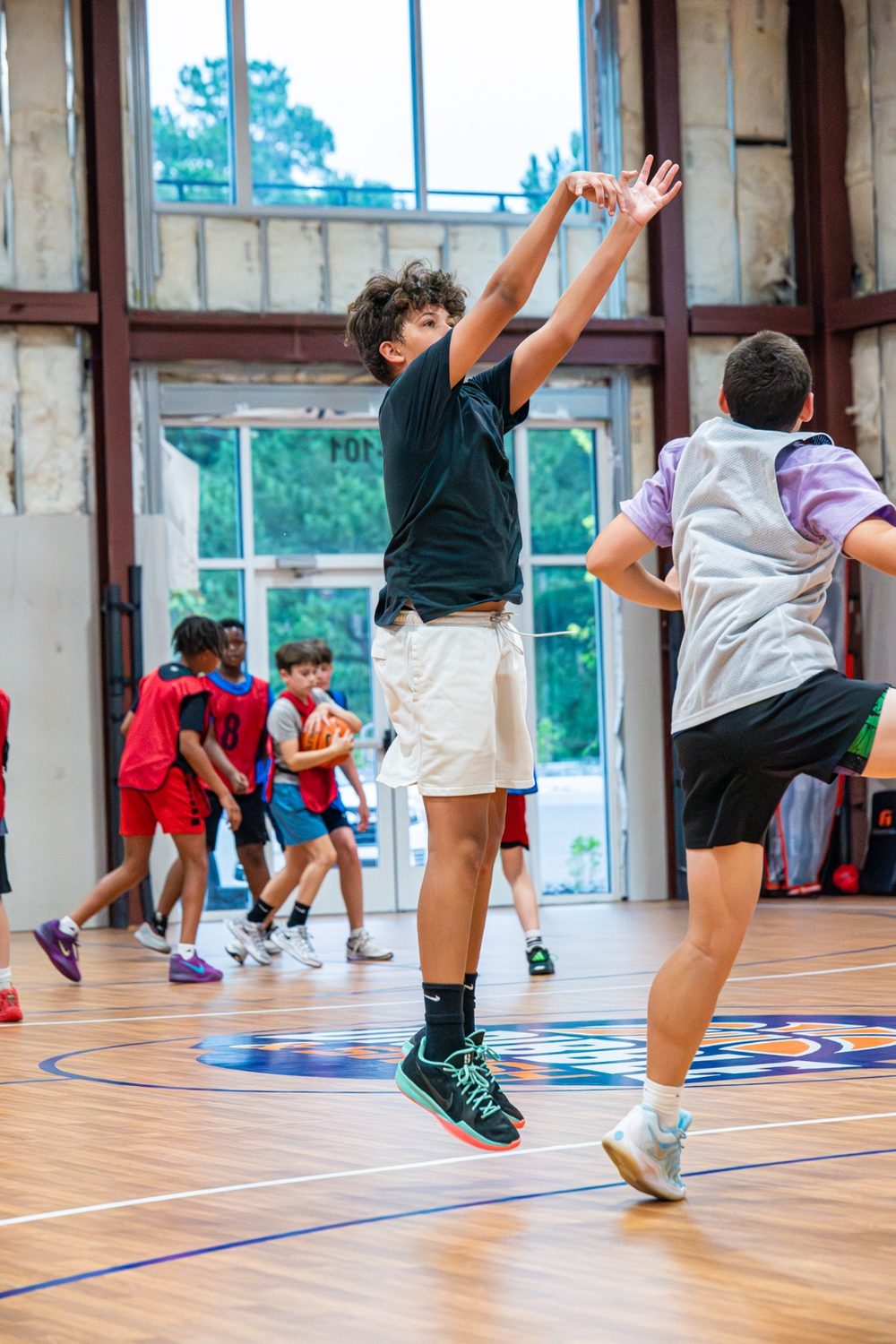 An athlete elevating for a jump shot as a teammate closes out
