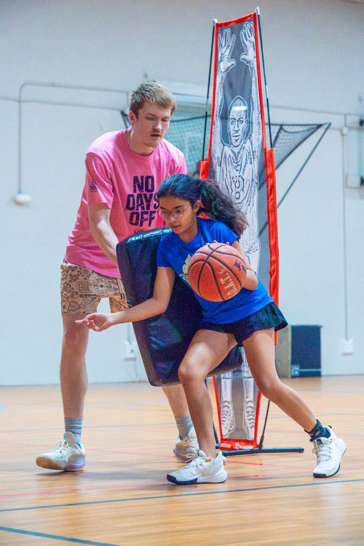 Coach holding a contact pad as an athlete finishes through the bump
