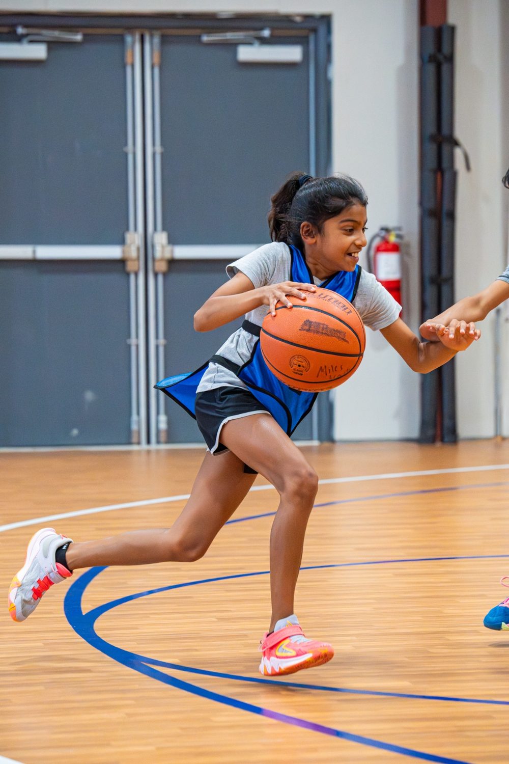 An athlete driving to the basket as a defender closes in