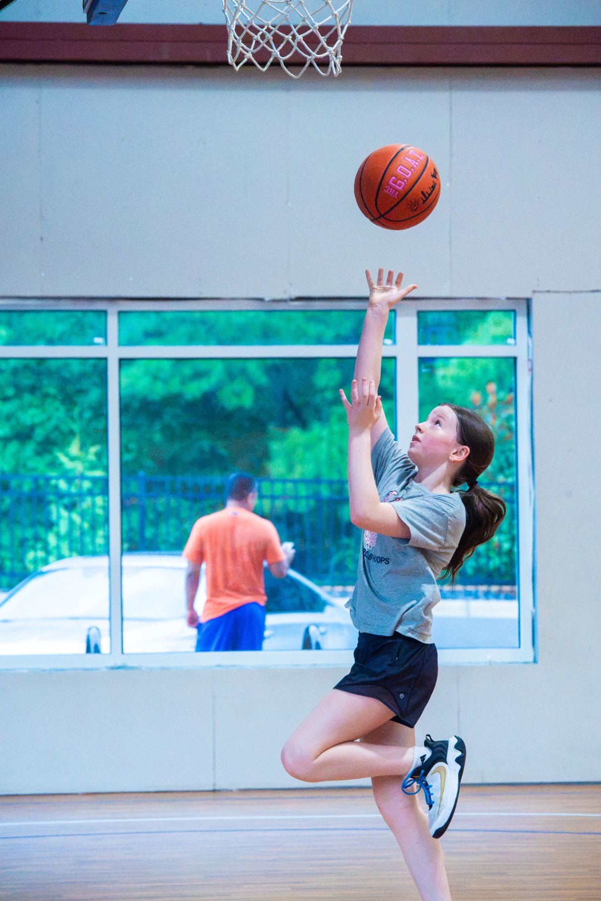 Young athlete elevating for a soft one-handed floater under the rim