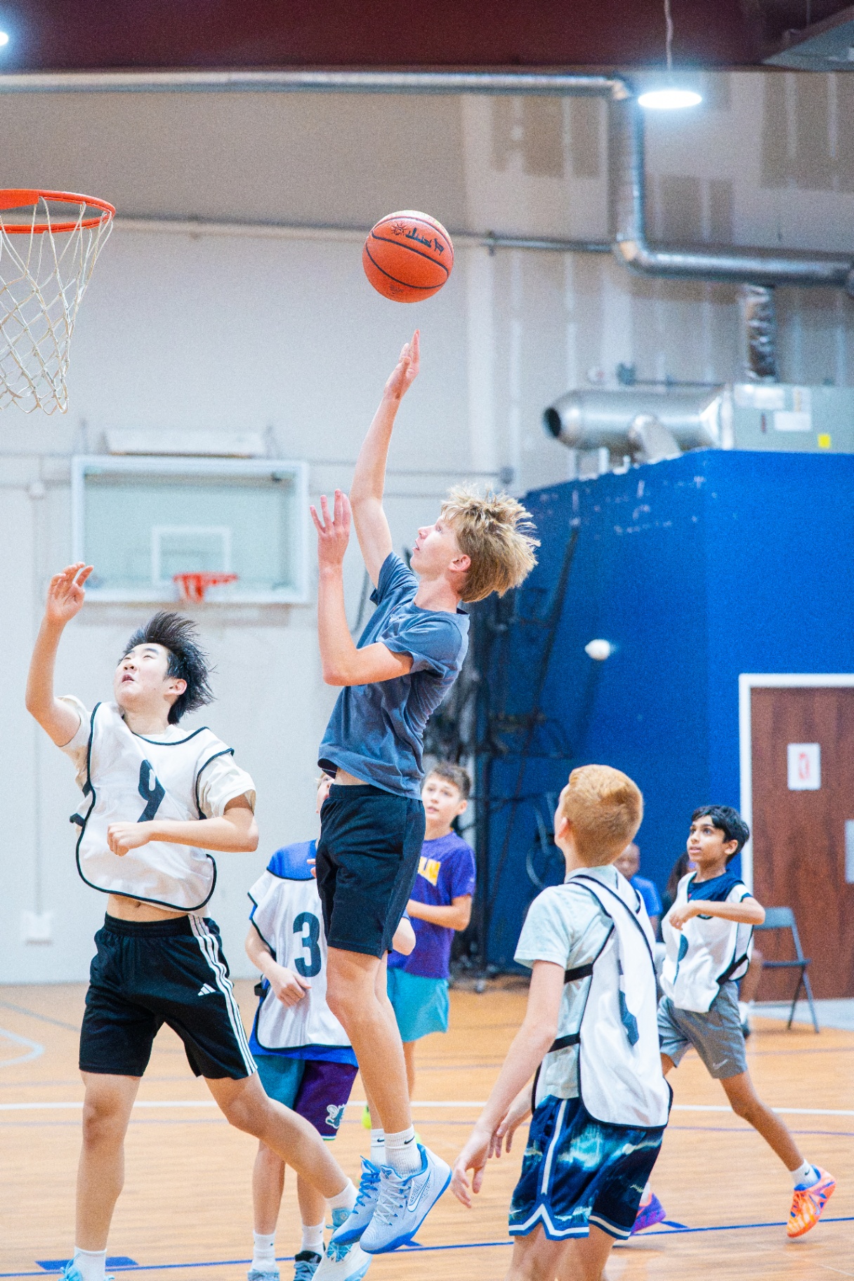 Athlete elevating for a tough shot in traffic with defenders closing from all sides