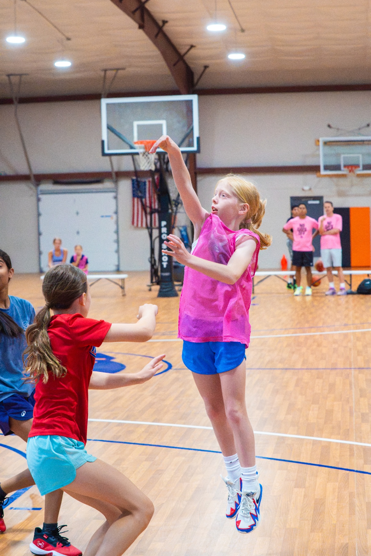 Athlete rising for a contested jump shot during a live game