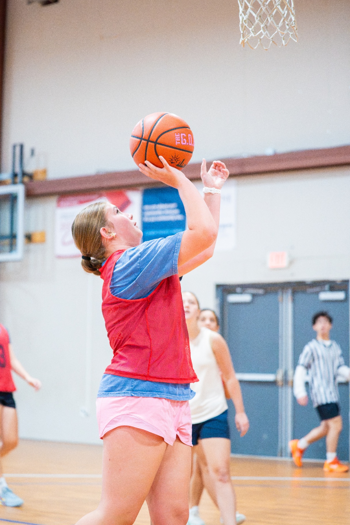 Athlete rising for a layup with defenders trailing during a Saturday scrimmage