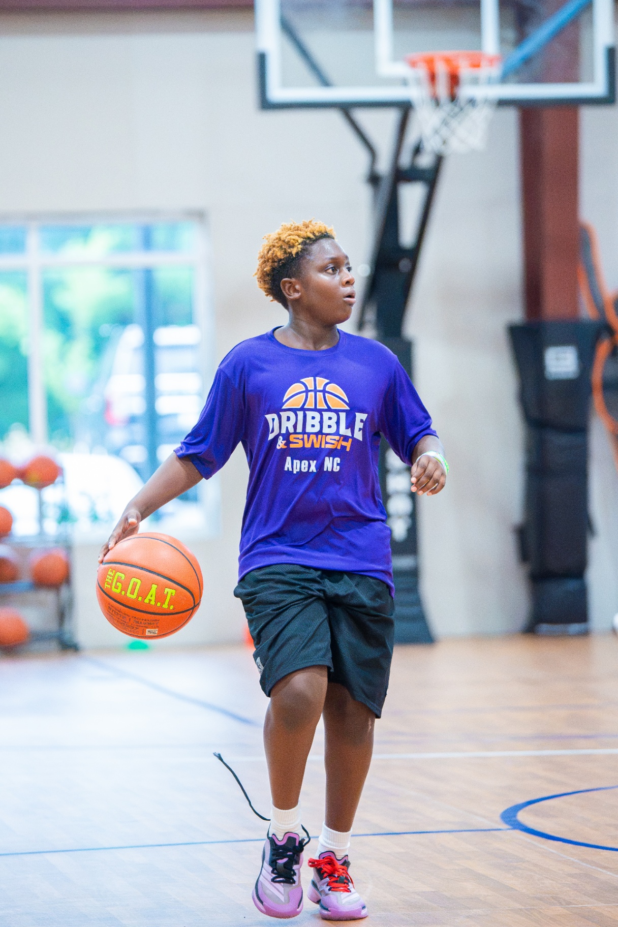 Player in a purple Dribble & Swish Apex NC shirt bringing the ball up the court