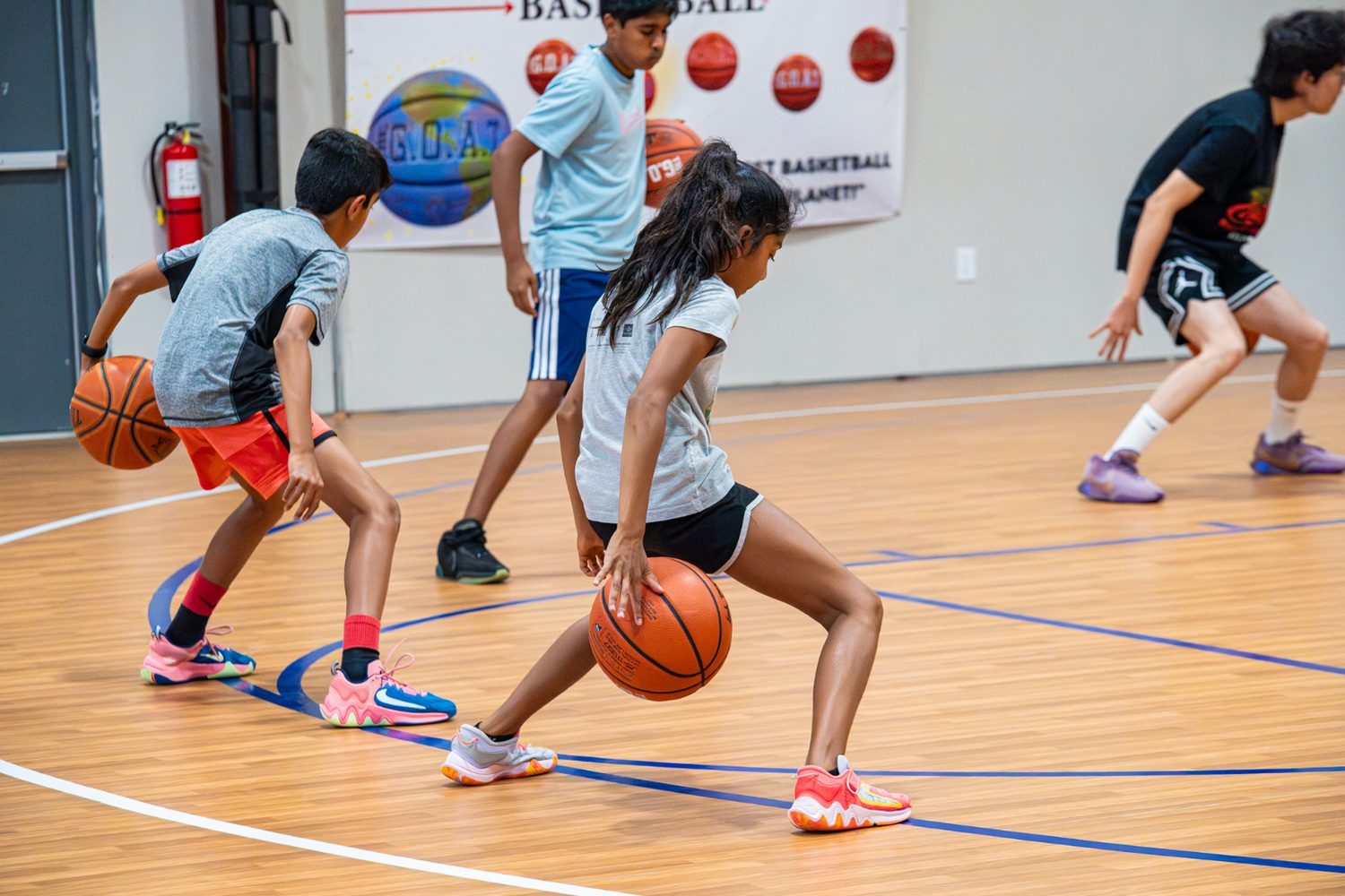 Athletes weaving through a dribbling drill with live defenders