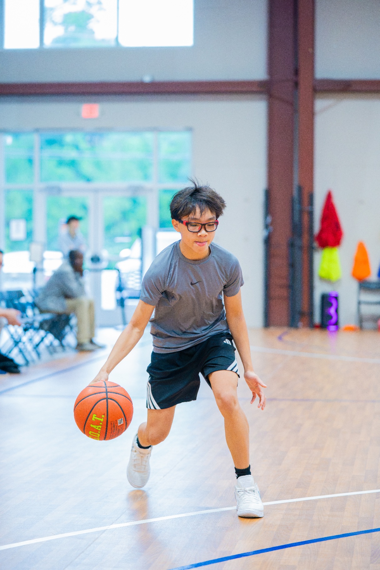 Athlete in glasses working a low crossover dribble down the court