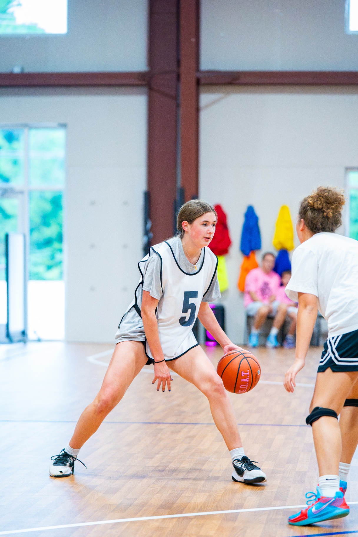 Young athlete in a #5 pinnie sizing up a defender in a live one-on-one drill